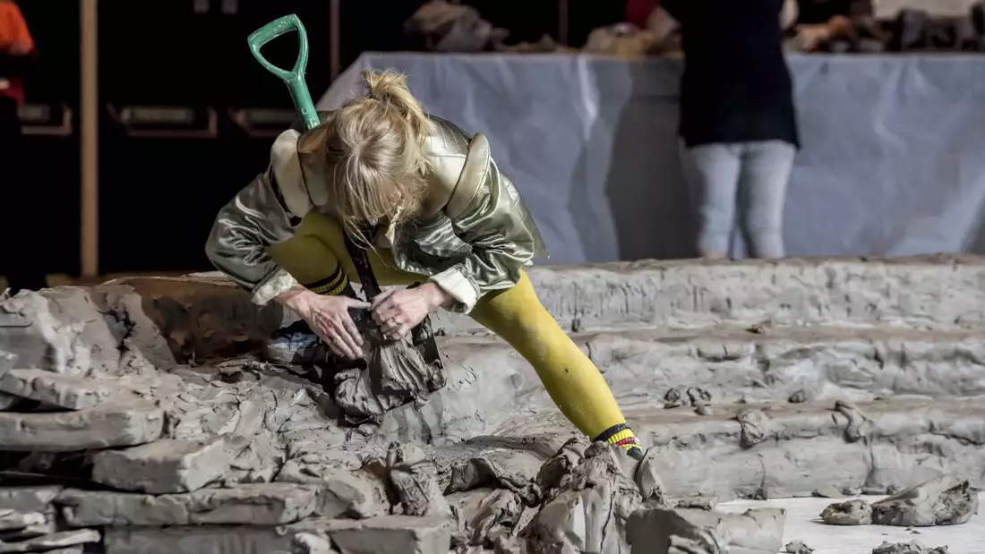 A performer building the clay installation during the Artist Takeover 2024