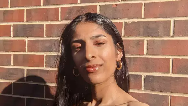 Headshot of Girl Called Sim stood in front of a brick wall