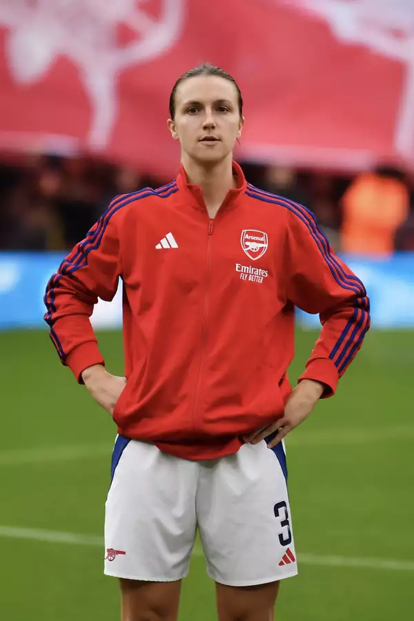 Lotte Wubben-Moy wearing an Arsenal kit stood on the pitch