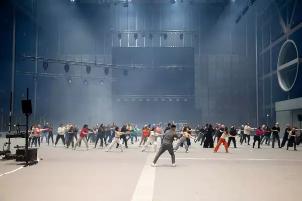 A diverse group of people dancing in a large warehouse space