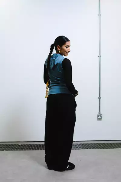 Ayesha Ali stood facing a wall and looking behind her