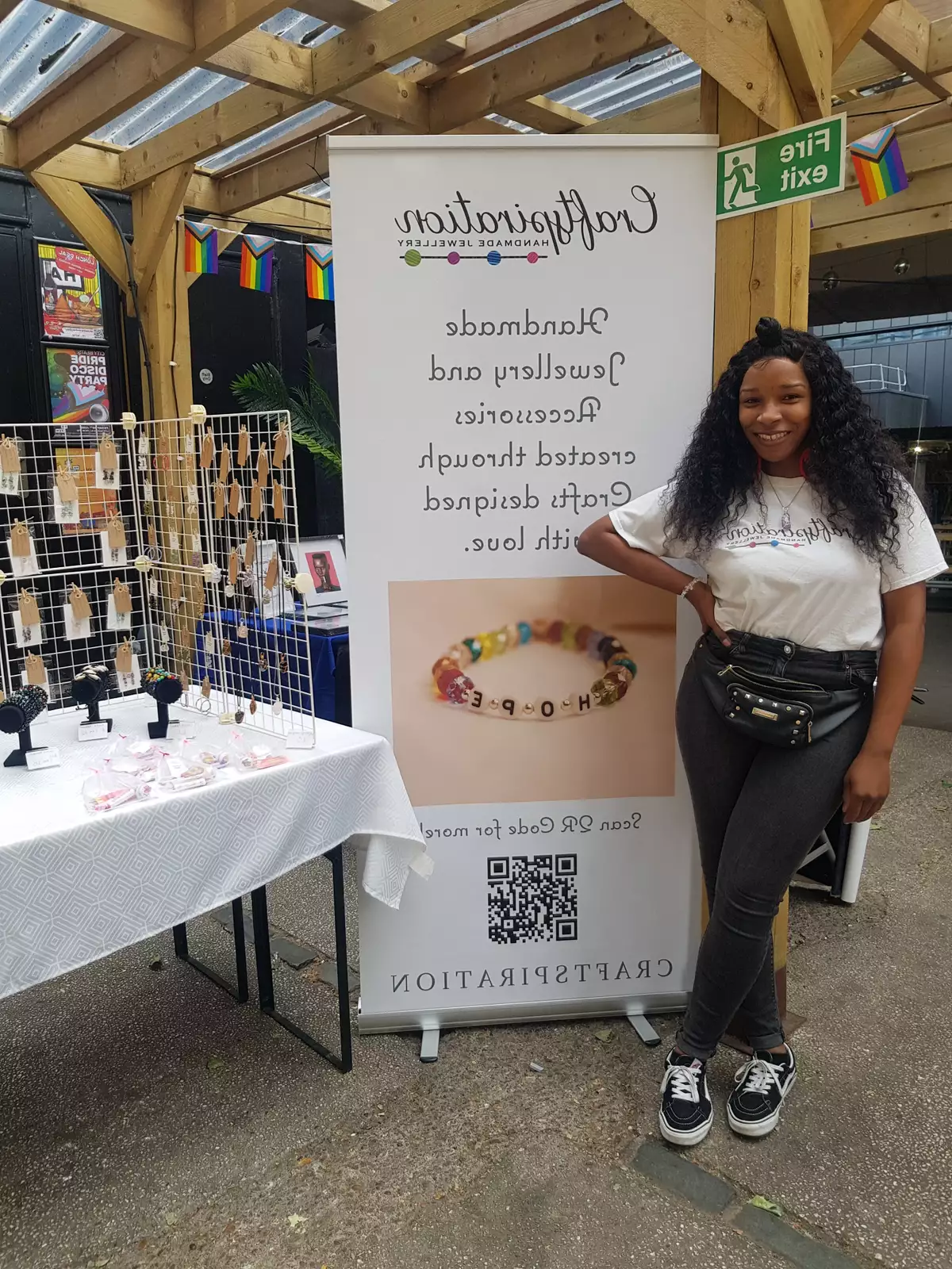 A trader smiling in front of a stand that reads 'Craftspiration'