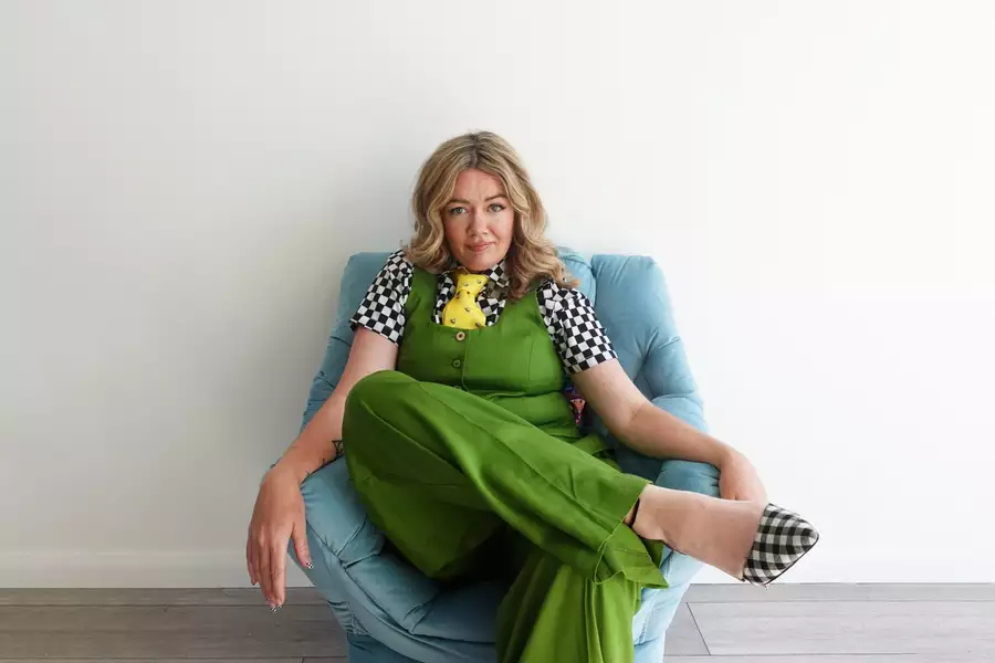 Serena Terry sat on a chair wearing a bright green jumpsuit
