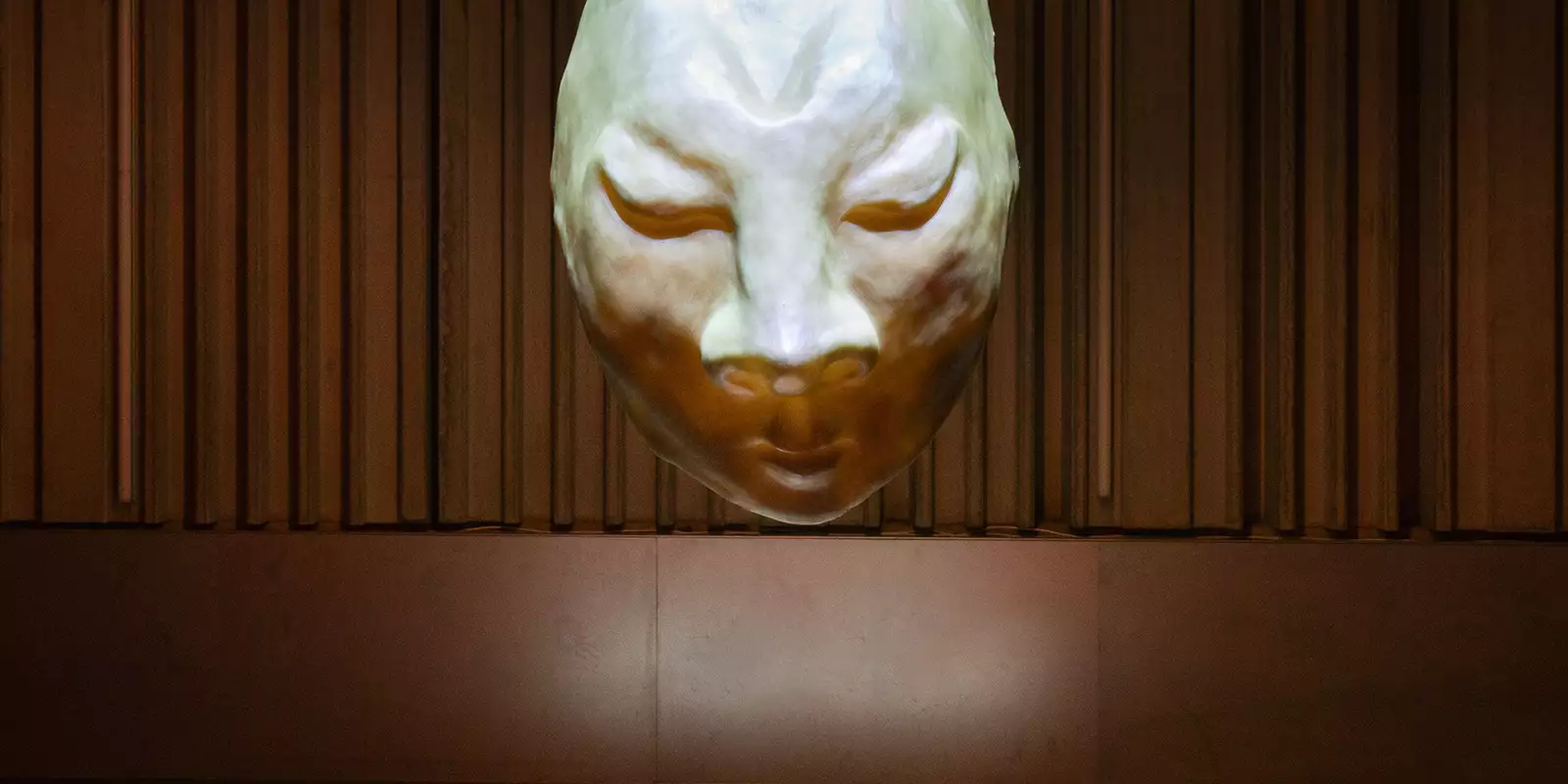 An artwork showing a mask hanging from the ceiling in Football City Art United