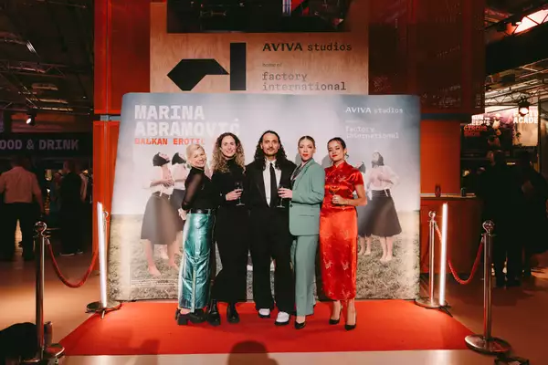 Five people dressed up in front of a Balkan Erotic Epic step and repeat