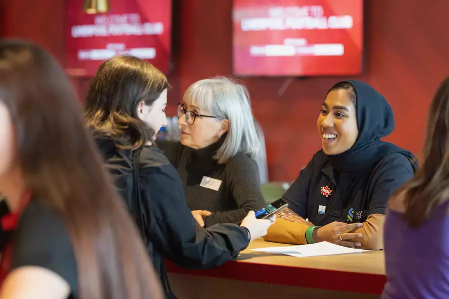 A mentor talking to a younger mentee during a speed mentoring session
