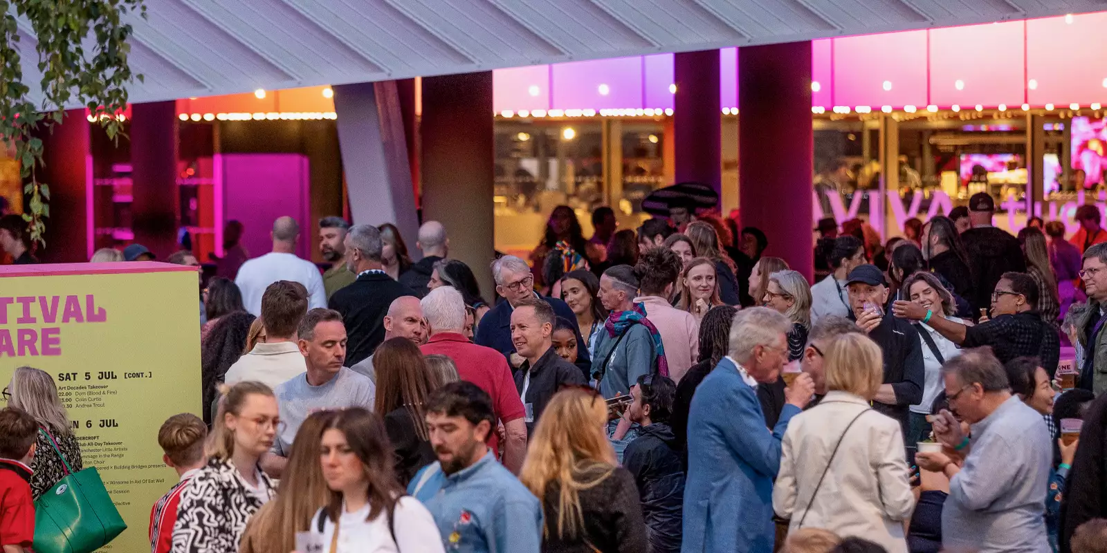 A large crowd of people chatting, drinking and sitting on Festival Square