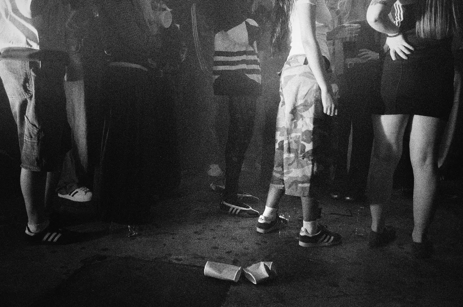 Black and white image of people in a club wearing adidas trainers