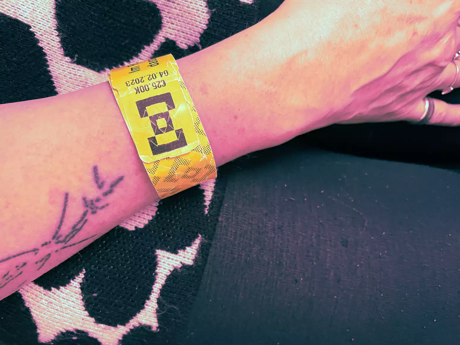 A person's arm with a club wristband