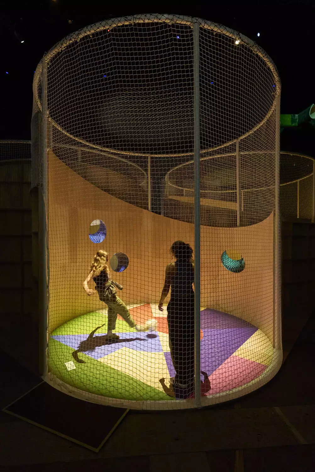 Two people kicking a ball inside a football cage as part of Football City, Art United