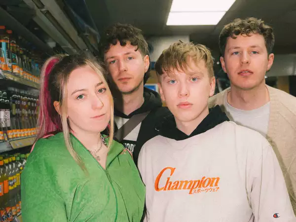 Four members of the band Foxglove photographed in a convenience store