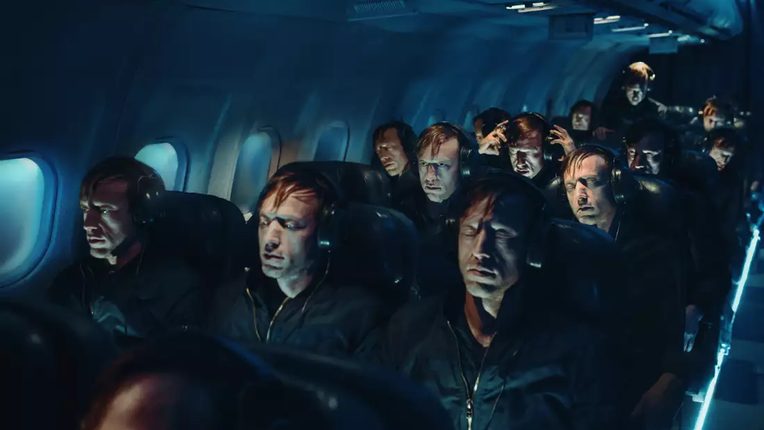 A surreal airplane cabin filled with identical men wearing headphones.