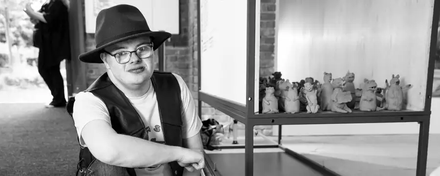 Black and white photograph of Dominic Bennett with his terracotta weasels