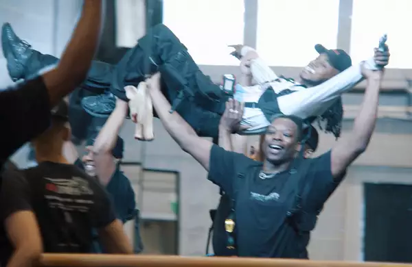 A still from In the Studio with Ivan Michael Blackstock, showing a group of dancers holding a dancer in the air next to a mirror