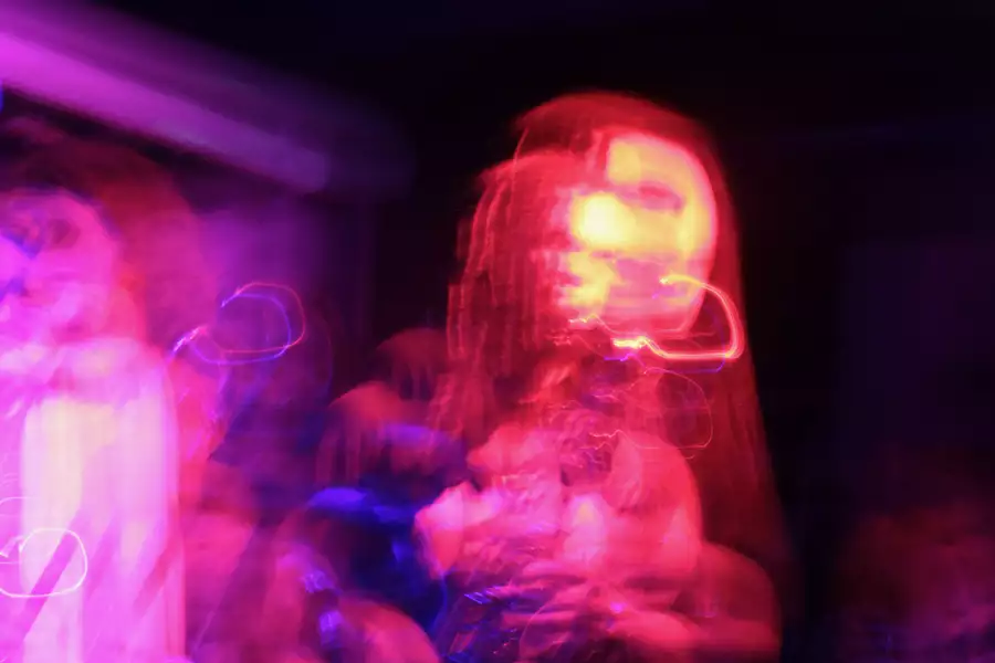 People performing on stage. The lighting is blurry and pinky purple.