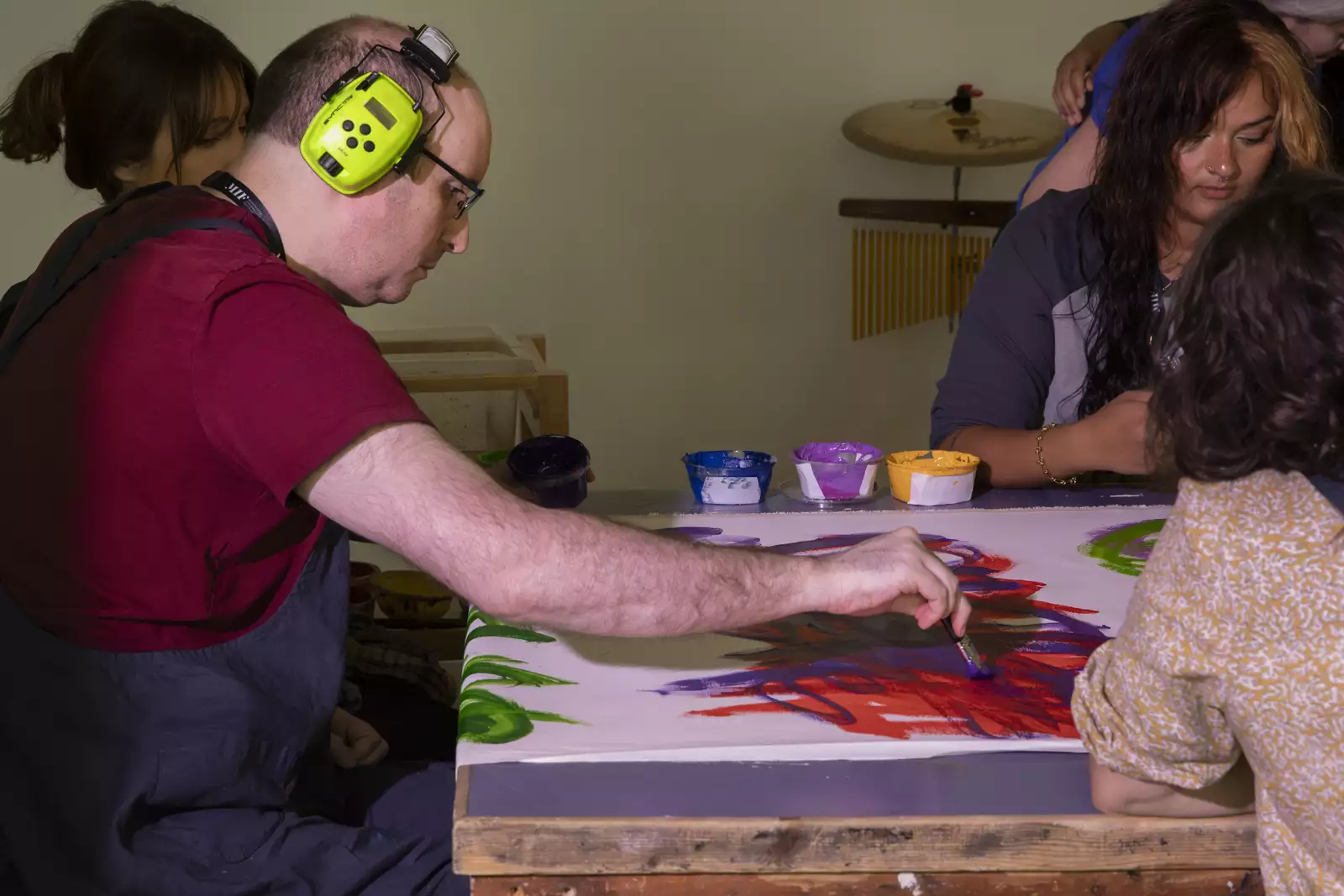 A photo of artist Michael Beard painting on a long roll of paper in The Lab a studio space at Aviva Studios