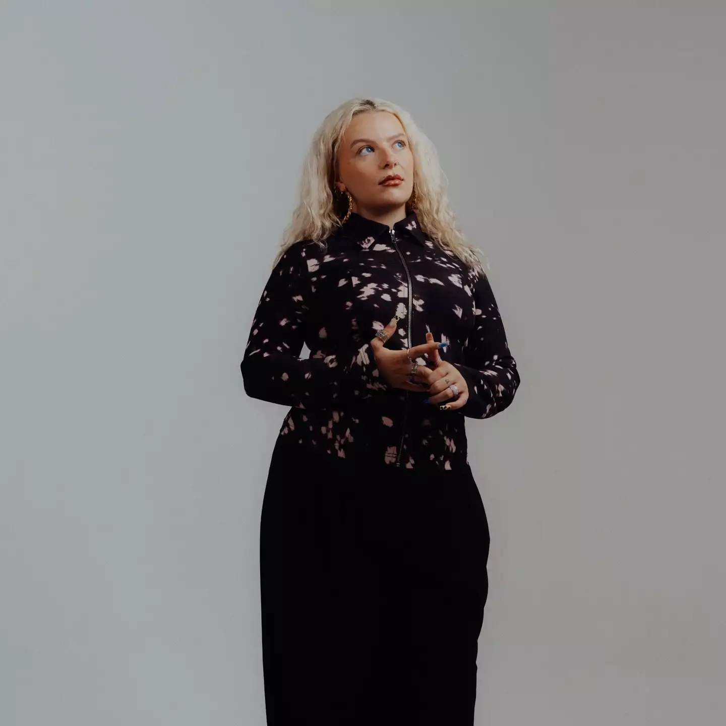 Megan Wroe stood against a grey background looking upwards