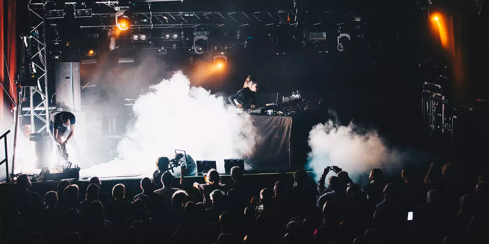 Artist Aisha Devi on stage with dj decks with plums of smoke