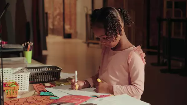 A child colouring in at a table in the Social