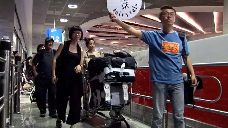 A group of people in an airport with a luggage trolley