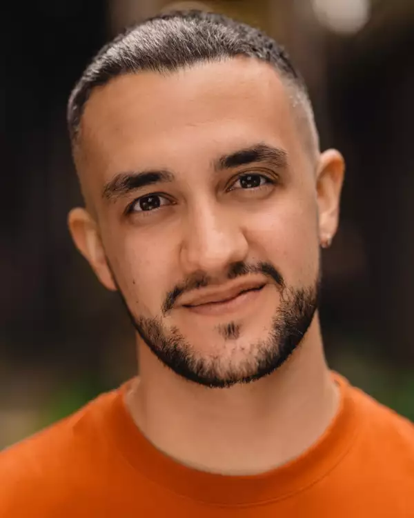 Headshot of Felipe Pacheco wearing an orange top