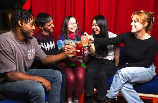 A group of people inside Aviva Studios drinking.