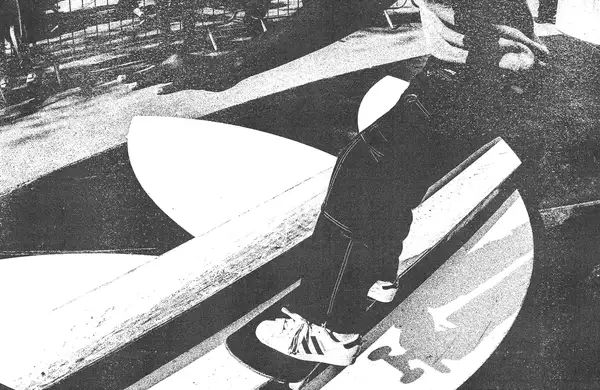 Black and white image of someone skateboarding on an Adidas skate ramp wearing Adidas trainers