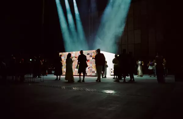 A group of people watching 54: Manchester's installation in the Warehouse.