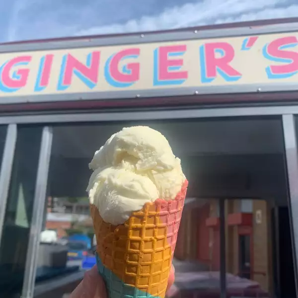 An ice cream from Ginger's Ice Cream being held up in front of their van
