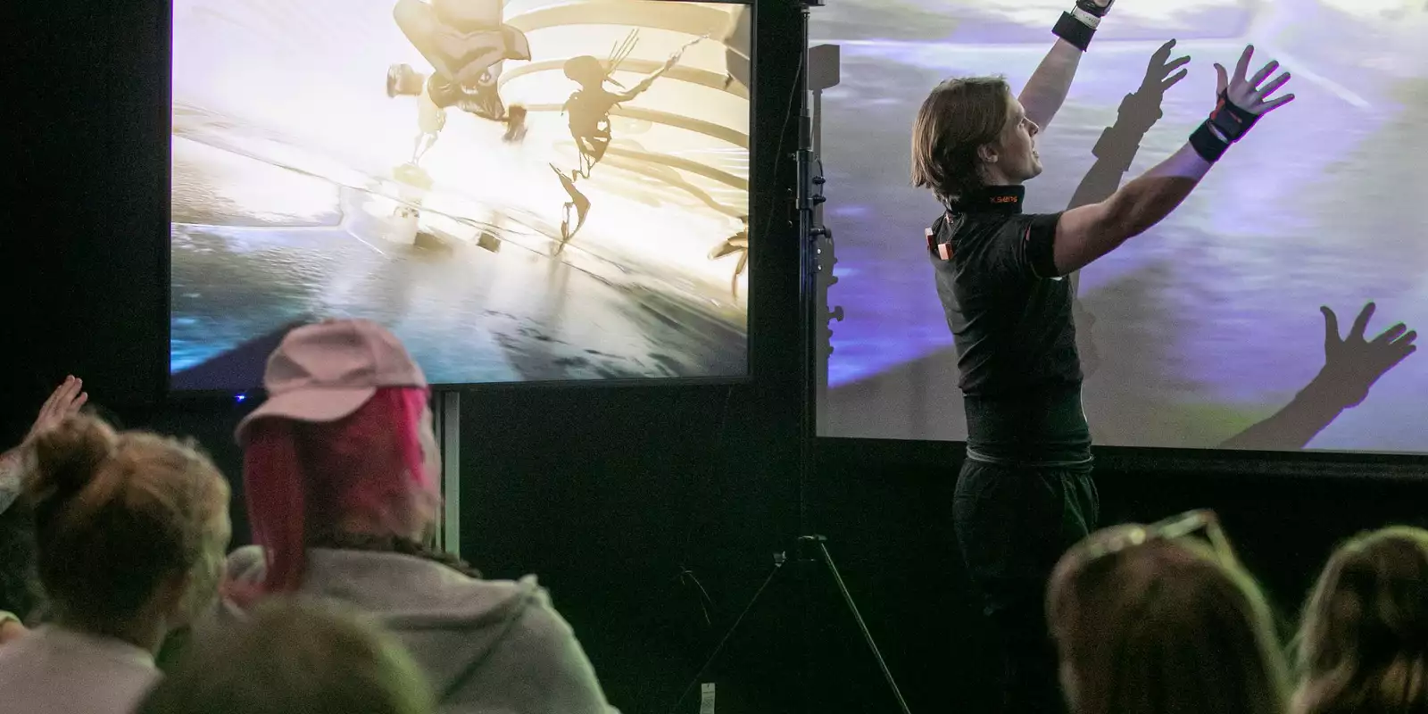 A man presenting in front of a digital screen