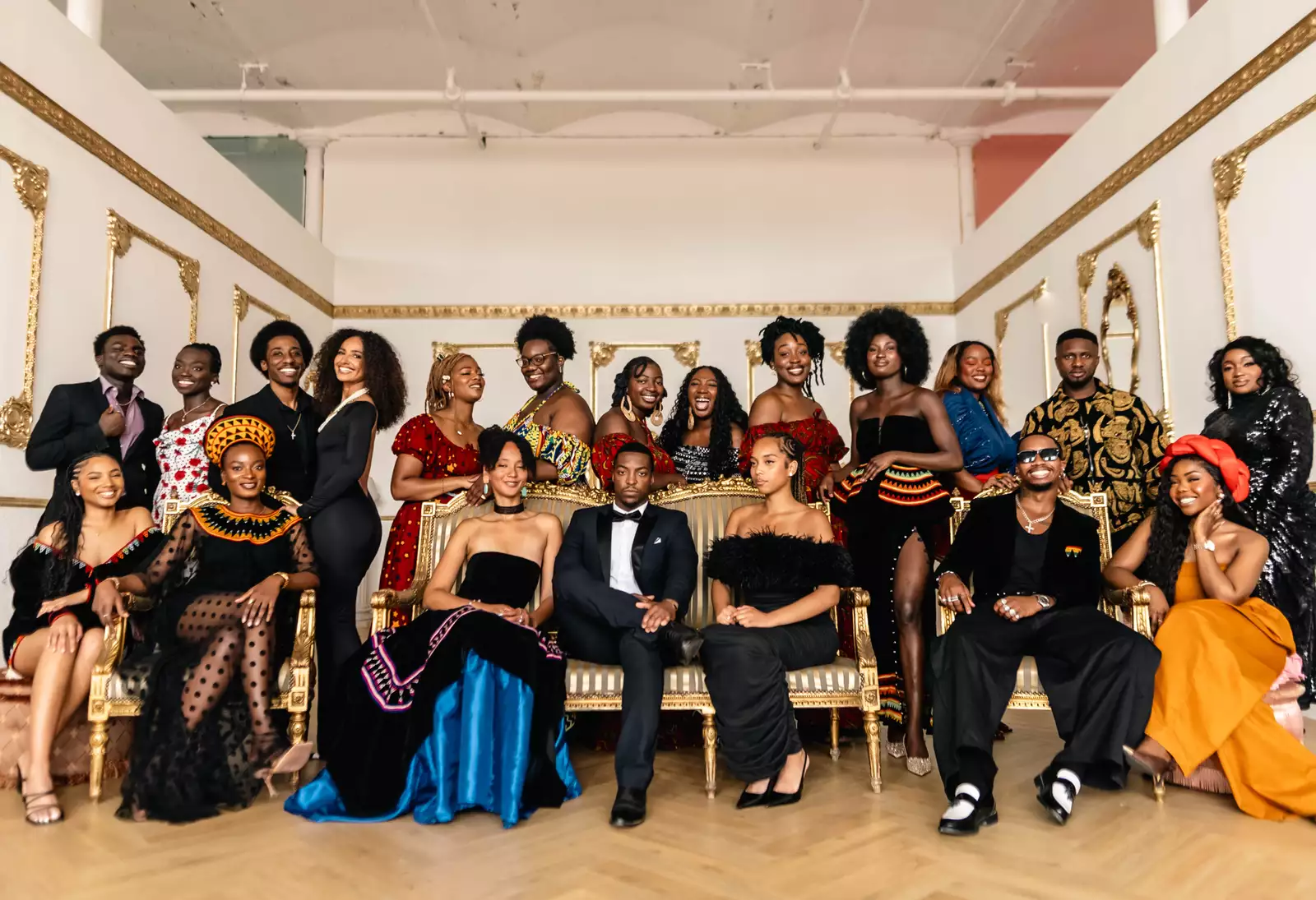 Group photo of the performers at Black Creative Trailblazers, wearing cultural attire and black tie in a ball room