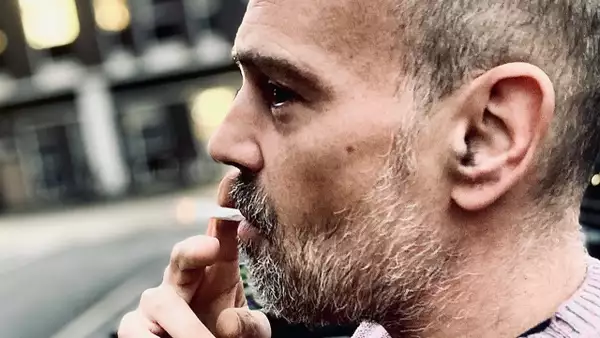 Close-up photo of DJ Rapha wearing a light purple jumper and smoking