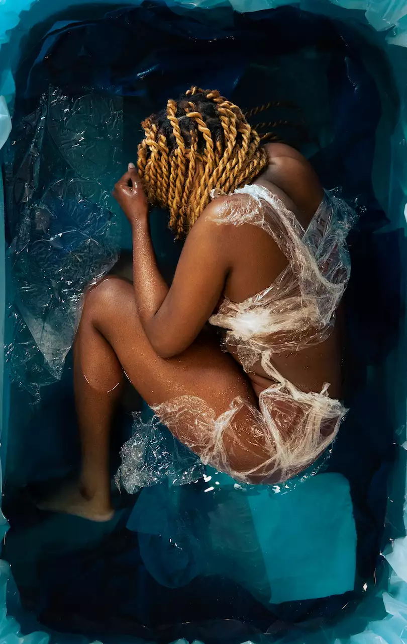 A naked person in a foetus position wrapped in plastics