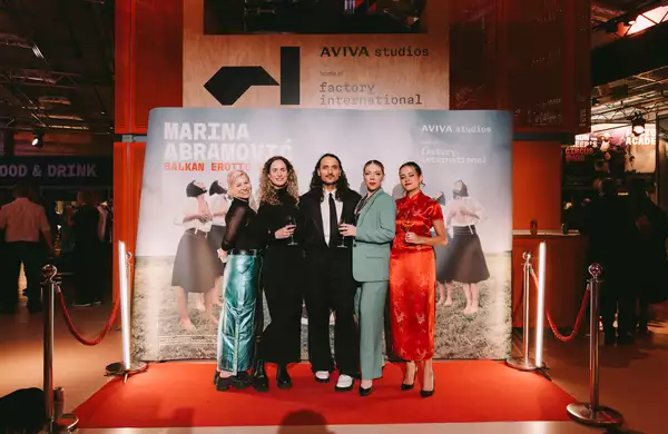 Five people dressed up in front of a Balkan Erotic Epic step and repeat