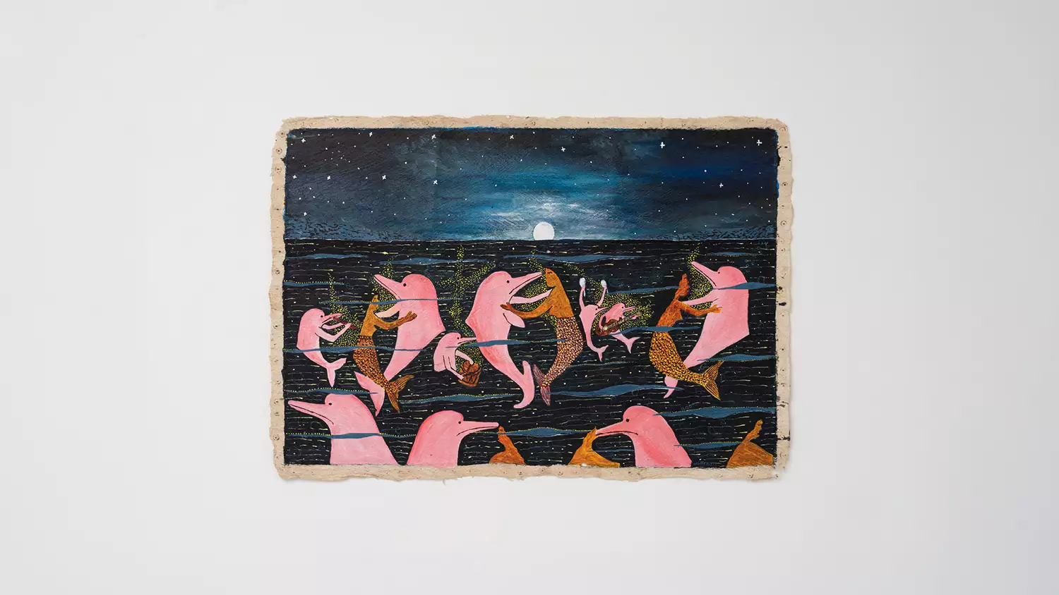 An artwork by Santiago Yahuarcani, showing dolphins and mermaids. The artwork is displayed on a white wall.