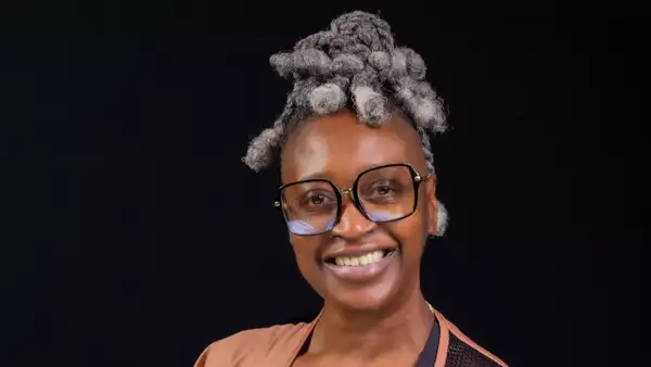 Headshot of SNO smiling, wearing a light pink/orange jacket