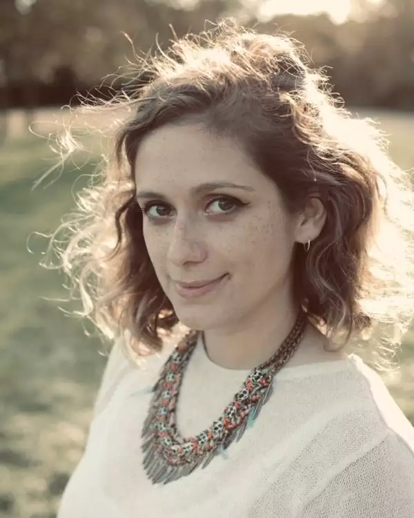 Headshot of FRANCESCA MURRAY-FUENTES wearing a colourful necklace and white top