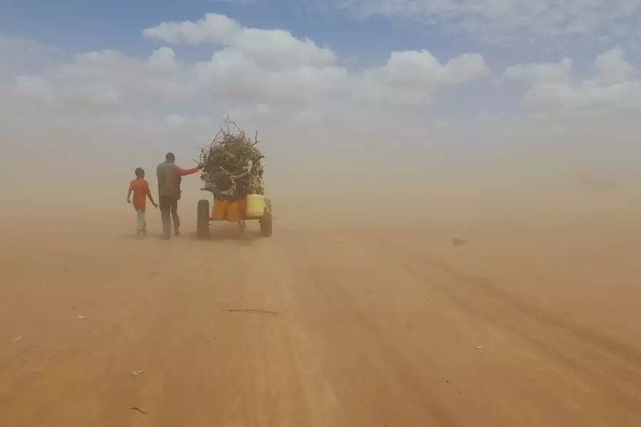 Still from Human Flow showing people walking through a desert