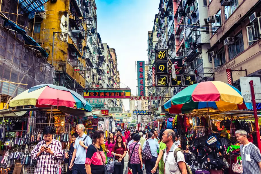 A street scene in Hong Kong, showing a busy market filled with people