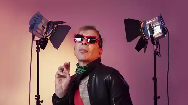 David Hoyle wearing sunglasses with two camera lights