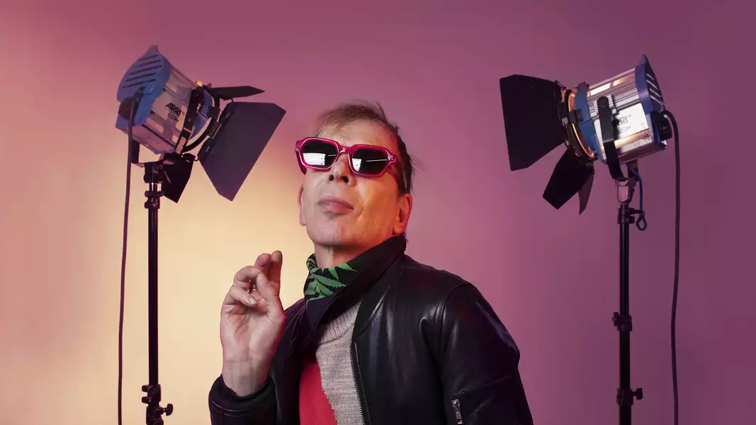 David Hoyle wearing sunglasses with two camera lights