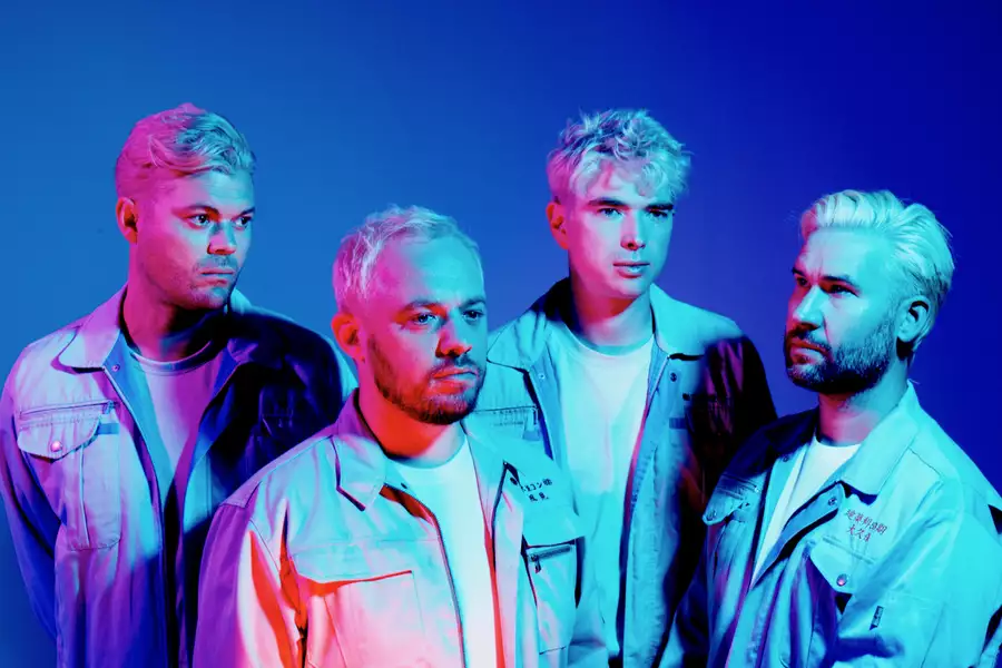Four members of Everything Everything on a bright blue background
