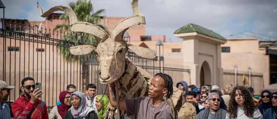 A crowd of people watching a puppet move through the Medina in Marrakesh, Morocco.