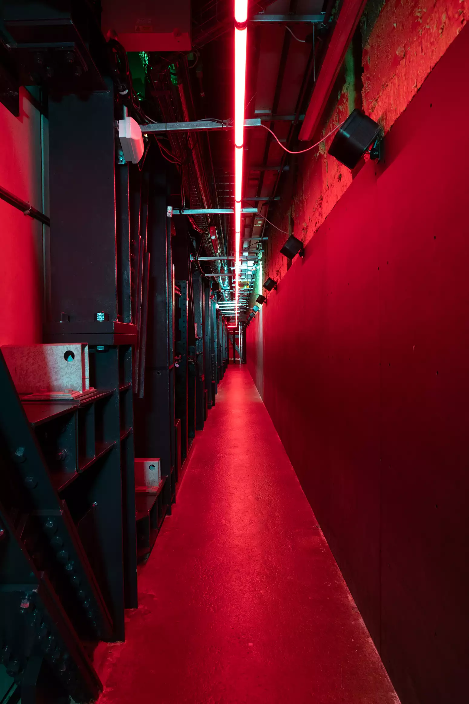 A corridor leading into Football City Art United. The lighting is red.