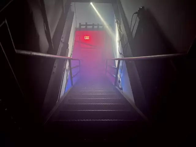 Club stairs leading down to an exit sign