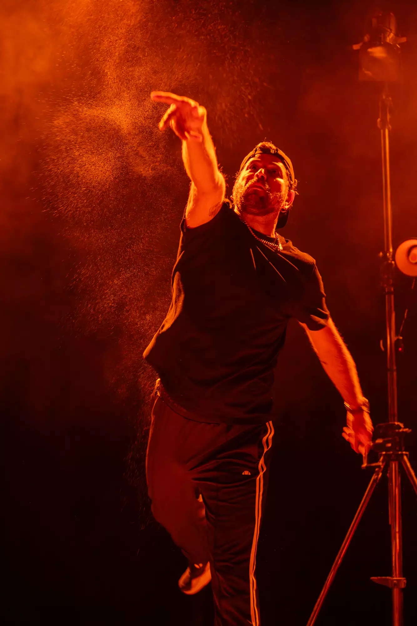 A man on stage throws something overhead.
