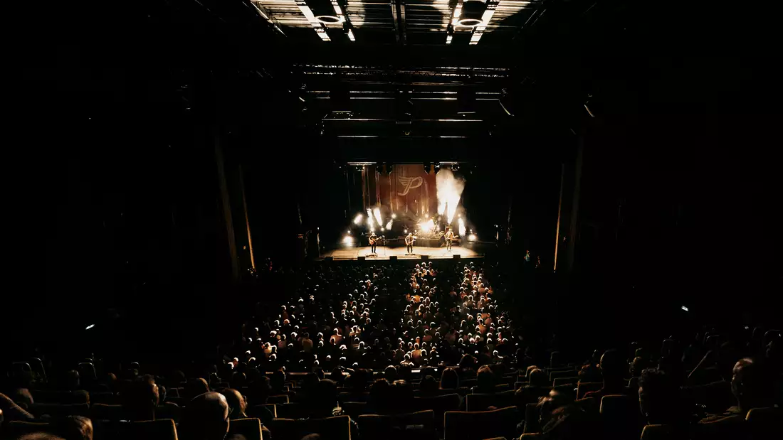 Pixies performing on stage with a huge crowd standing and seated