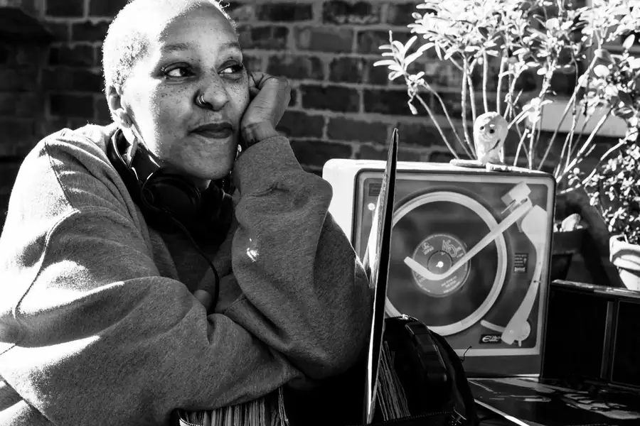 Andrea trout sat in a garden with a record player and laptop