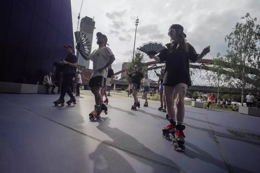 People roller skating with fans outside Aviva Studios in the sunshine