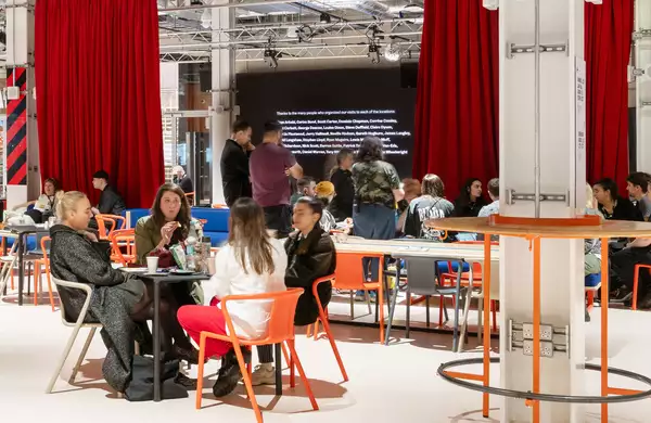 Visitors in Aviva Studios sitting down in the social area.